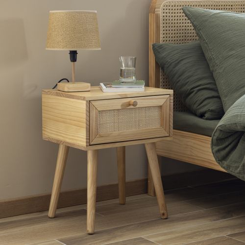 Petite table de nuit en cannage surmontée d'une lampe de chevet design