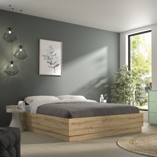 Lit coffre en bois décor chêne Terre de Nuit Teddy dans une chambre moderne aux murs verts.