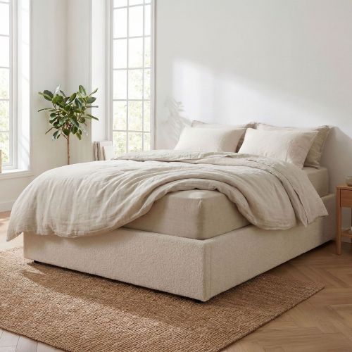 Vue d'un lit coffre en tissu sherpa texturé, intégré dans une décoration de chambre minimaliste et chaleureuse