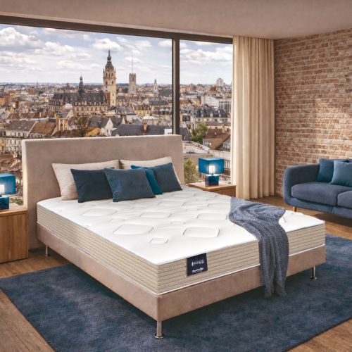 Matelas mousse HR ferme Dunlopillo Lilas 2 installé dans une chambre moderne avec vue urbaine.
