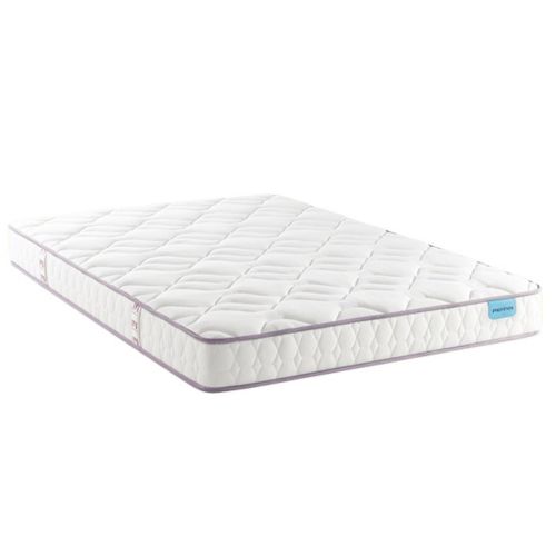Matelas latex ferme Merinos Cosy Lit posé sur son sommier dans une chambre corail.