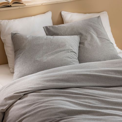 Parure Eden à rayures grises et blanches avec taies d'oreiller assorties dans une chambre lumineuse