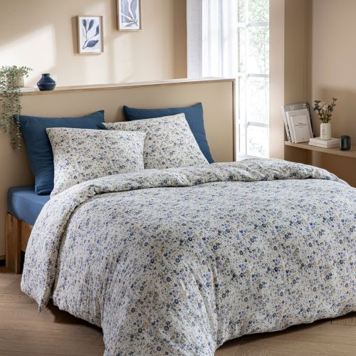 Chambre à coucher moderne décorée avec une parure fleur bleue et des draps en coton