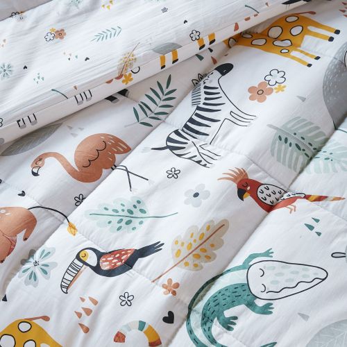 Détail des imprimés animaux girafe et zèbre sur le tissu en coton de la parure savane