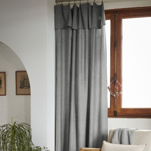 Rideau lyocell coloris anthracite suspendu dans une chambre à coucher lumineuse et épurée