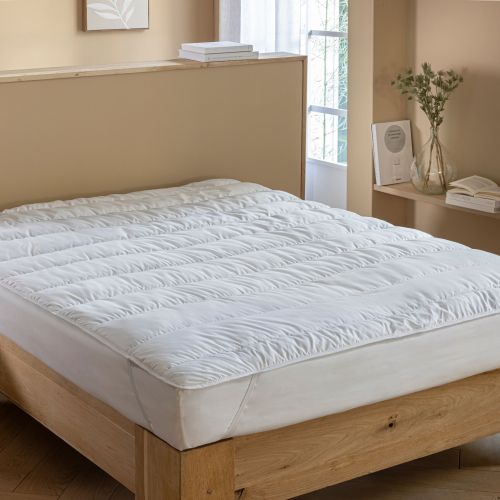 Surmatelas moelleux anti-acariens Someo installé sur un lit pour un confort cocooning