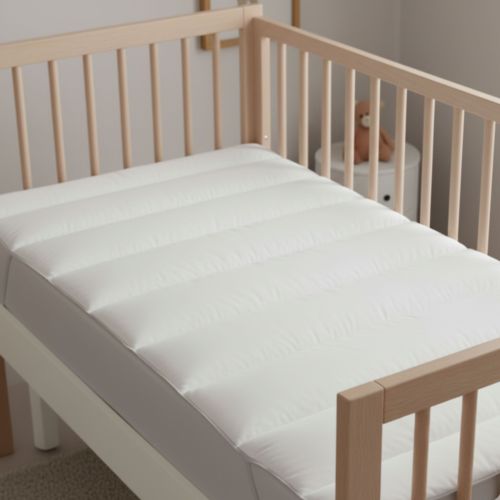 Vue de dessus d’un surmatelas moelleux pour lit bébé