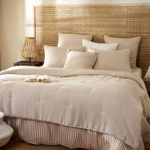 Taie d'oreiller Ninon en coton à rayures beige dans une chambre lumineuse et chaleureuse