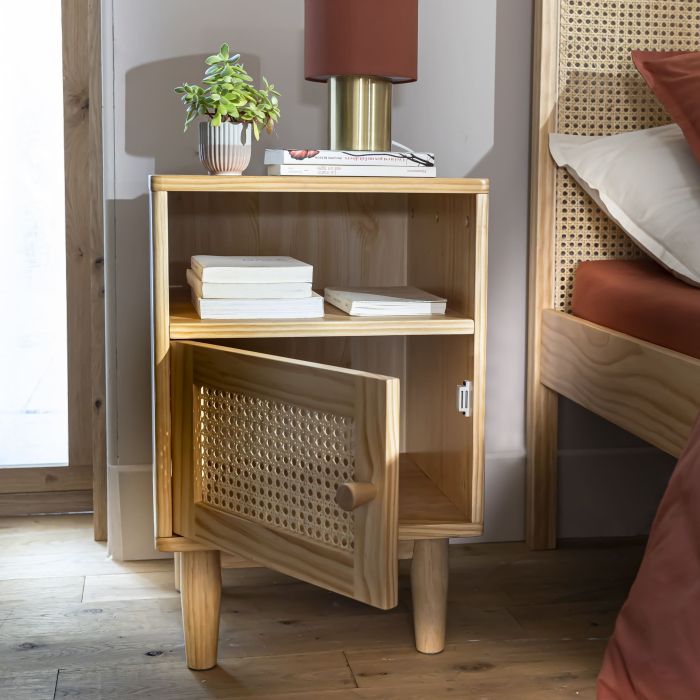 Table de chevet avec porte et niche placée à côté d'un lit