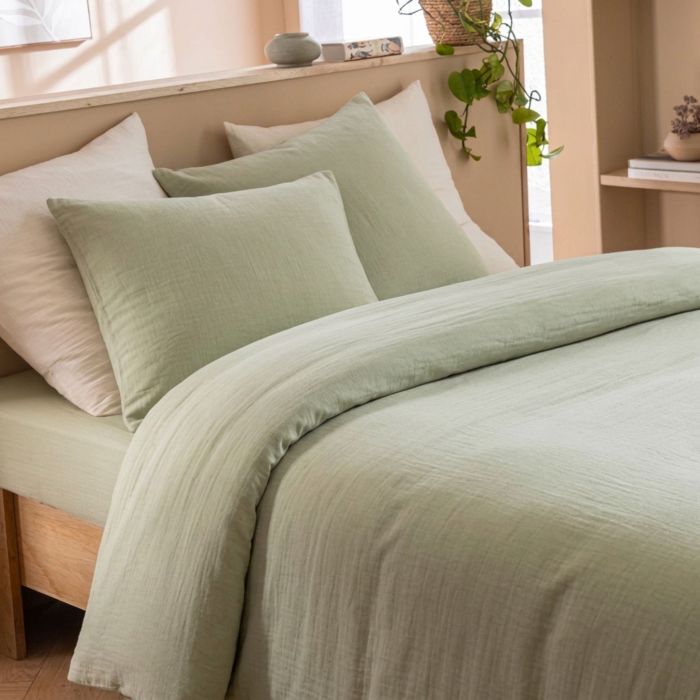 Housse de couette gaze de coton vert dans une chambre lumineuse au style épuré