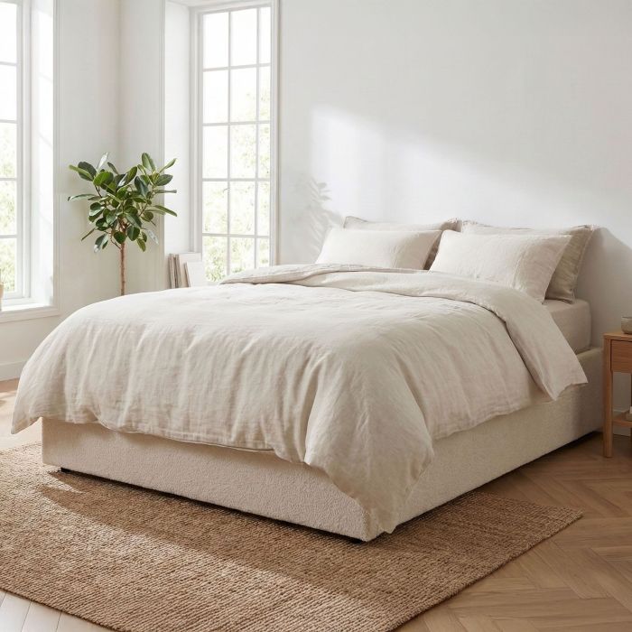 Lit coffre sherpa ivoire dans une chambre à coucher scandinave lumineuse et naturelle avec parure en lin