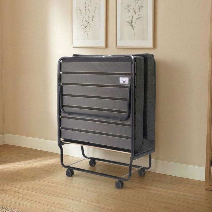 Lit pliant sur roulettes avec matelas  rangé dans une chambre d'ami.