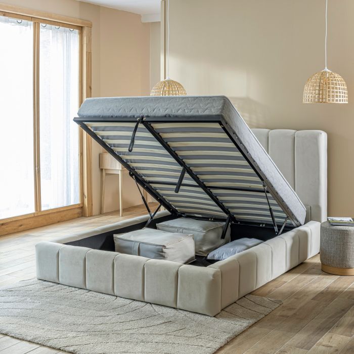 Lit coffre en velours matelassé beige avec coffre ouvert dans un décor de chambre lit au carré trois quart