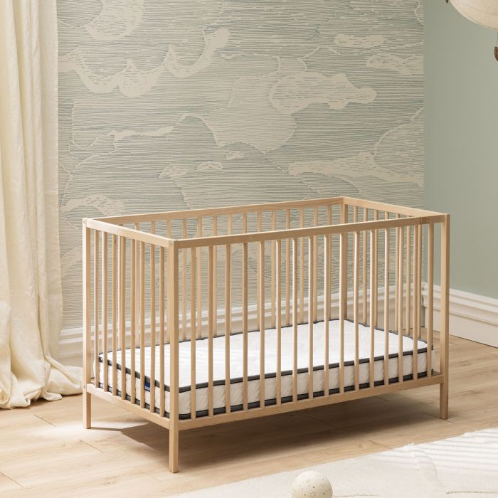 Lit en bois clair équipé du matelas bébé en mousse ferme Bultex Tichou.