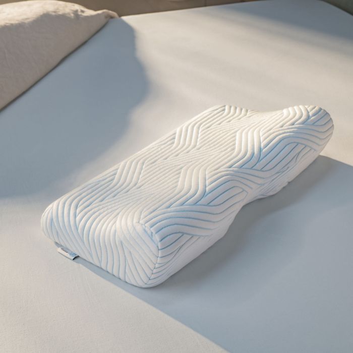 Oreiller ErgoPlus Tempur disposé sur un lit moderne dans une chambre lumineuse et épurée