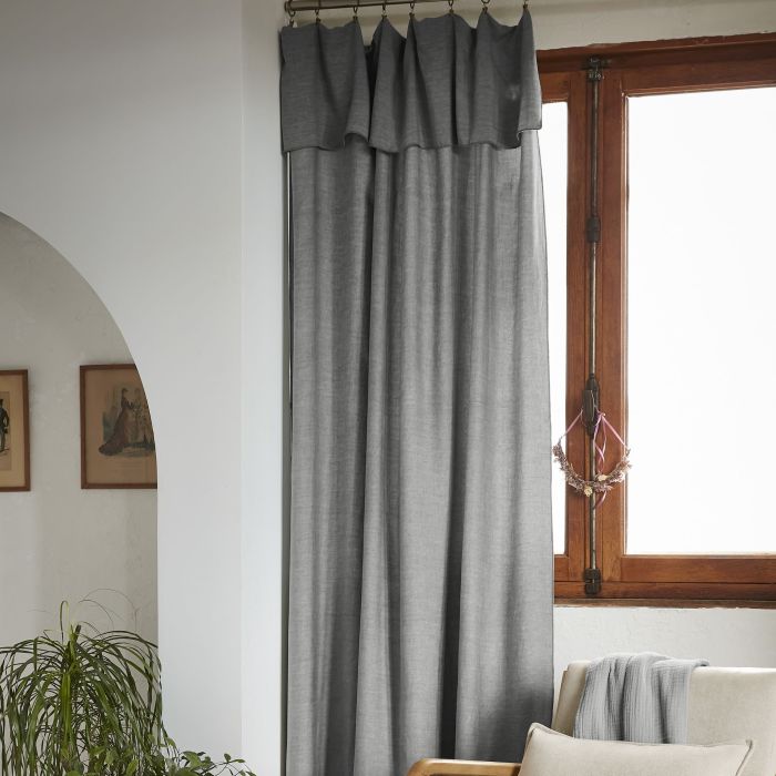 Rideau lyocell coloris anthracite suspendu dans une chambre à coucher lumineuse et épurée