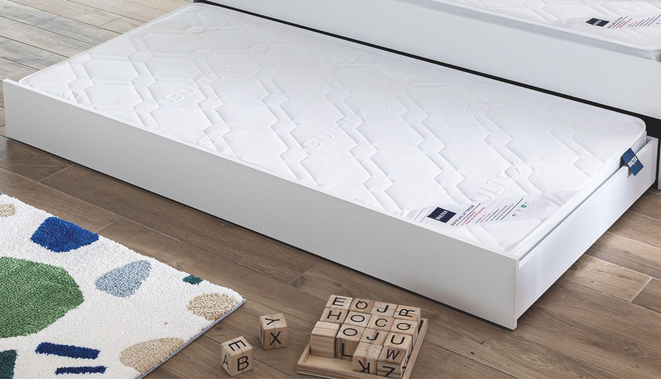 Matelas pour lit tiroir en mousse ferme Bultex visible dans le tiroir ouvert d&#039;un lit enfant.