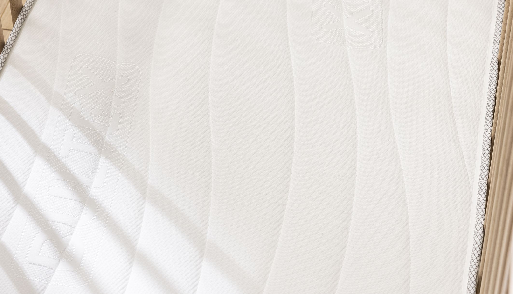 Zoom détaillé sur le coutil aux motifs ondulés de ce matelas Bultex bébé.
