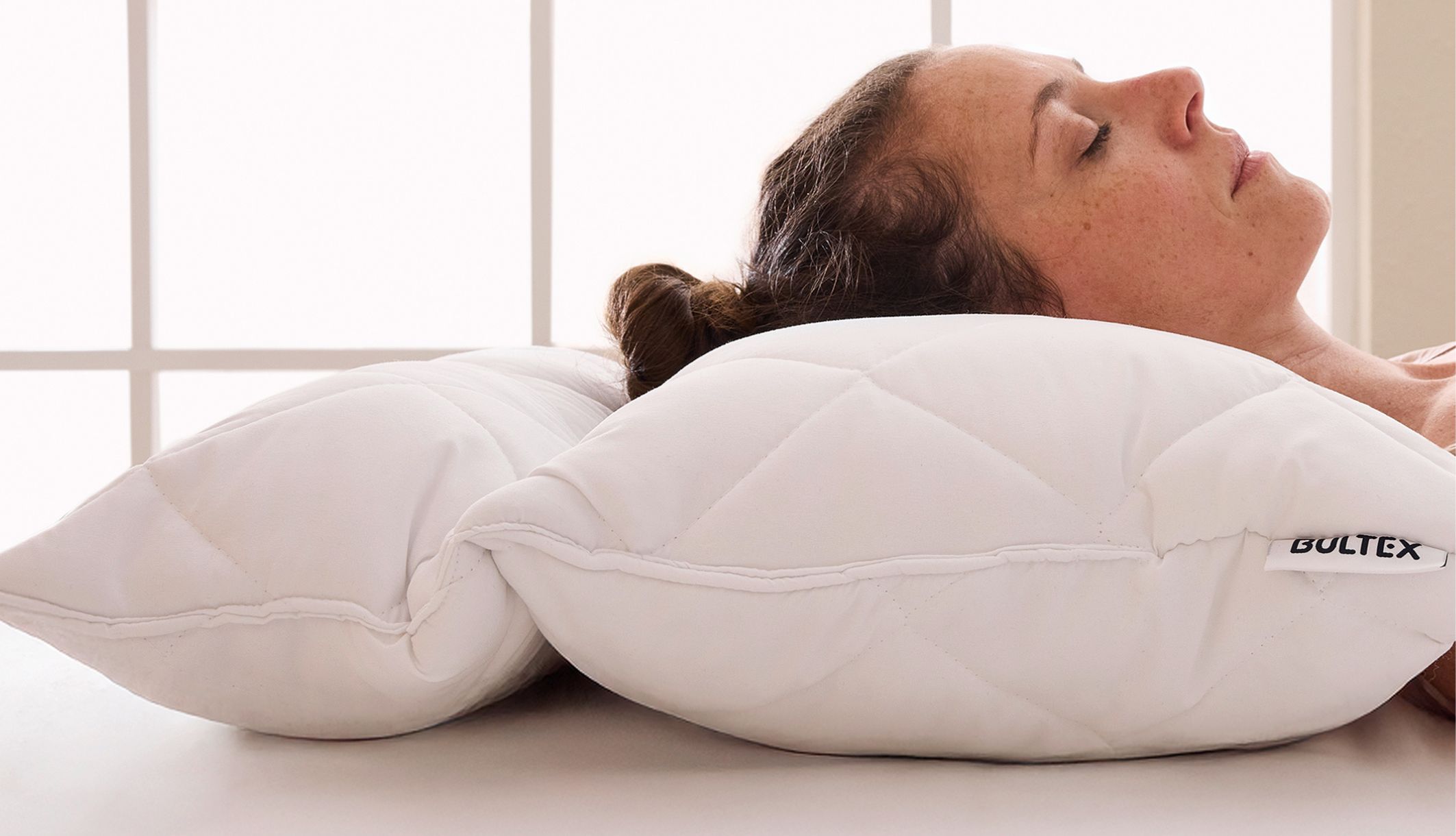 Femme dormant paisiblement sur l&#039;oreiller Bultex Memo 3-en-1 ergonomique inclus dans l&#039;offre.