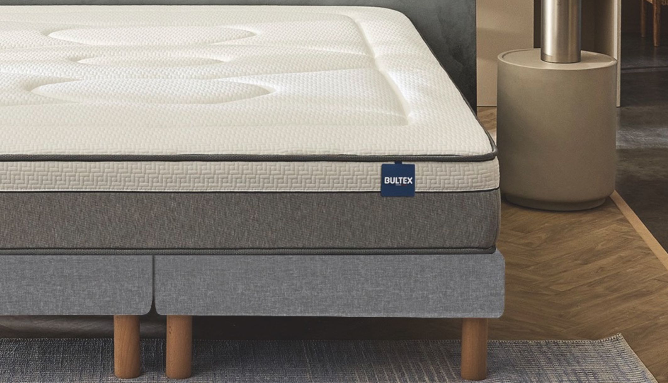 Vue de profil du matelas Bultex sur fond blanc, montrant son épaisseur et ses poignées.