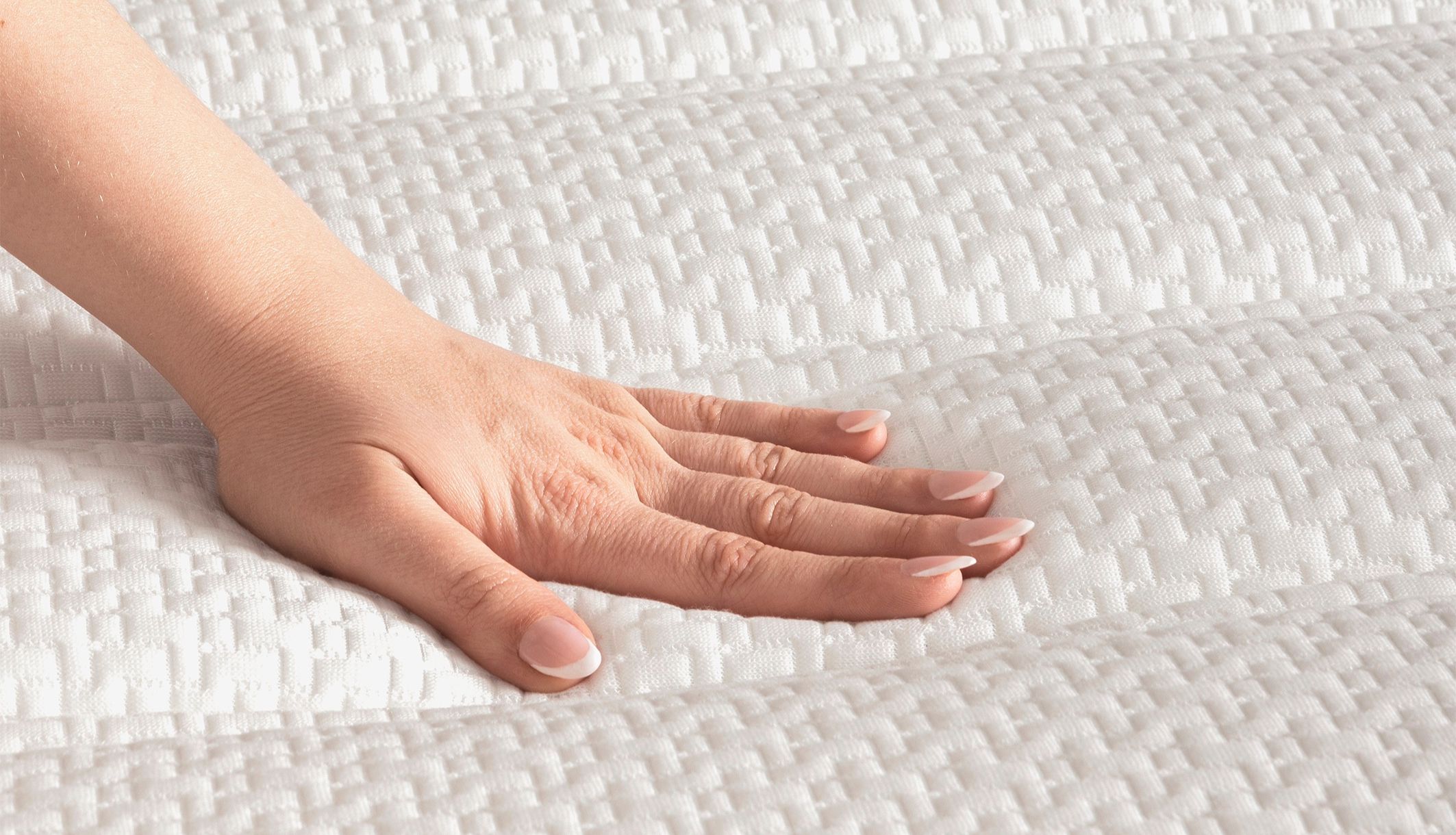 Main testant le moelleux et le coutil texturé de ce matelas Bultex relaxation.