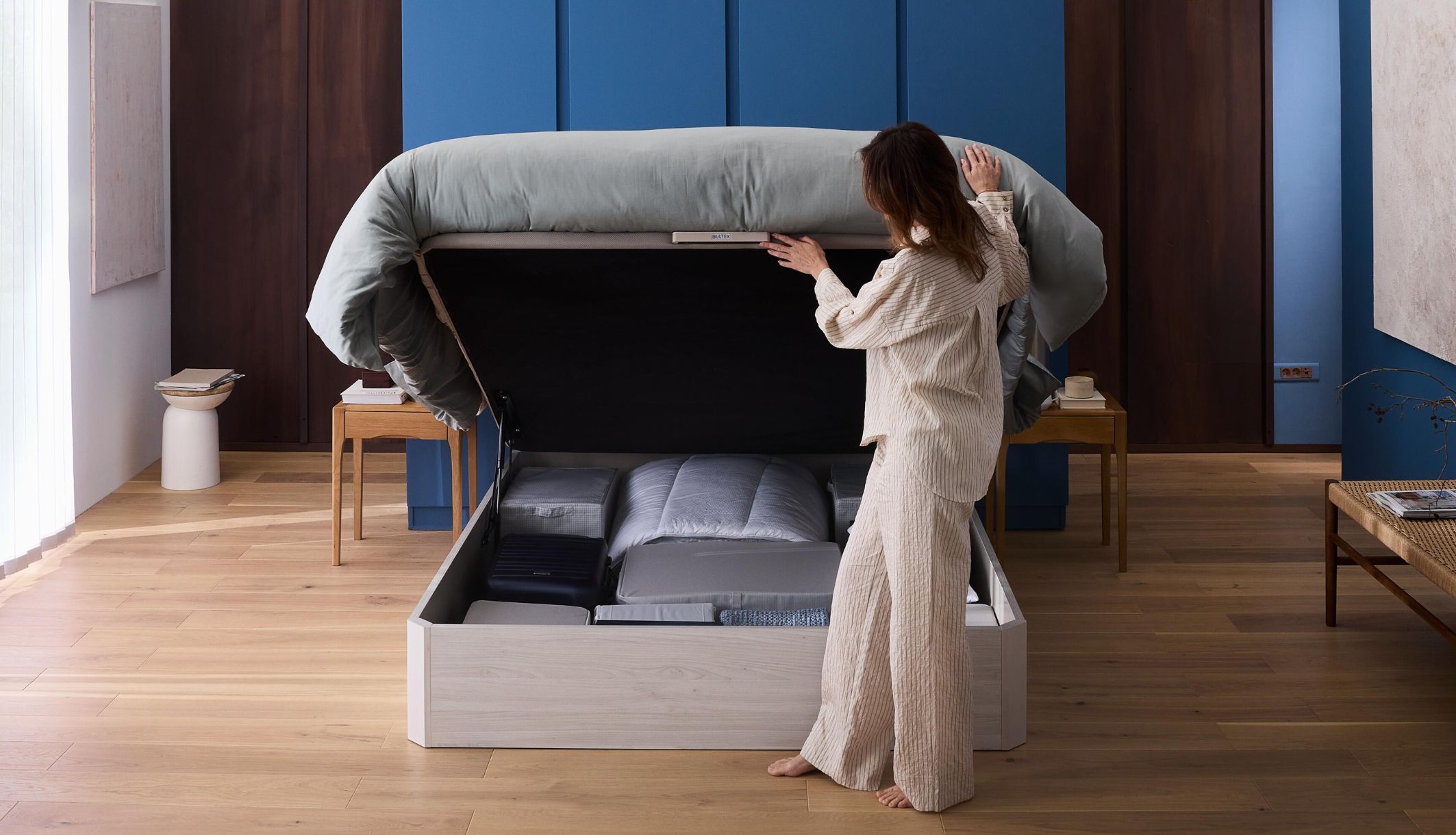 Femme ouvrant le lit coffre Space&#039;Up Bultex pour accéder à ses affaires
