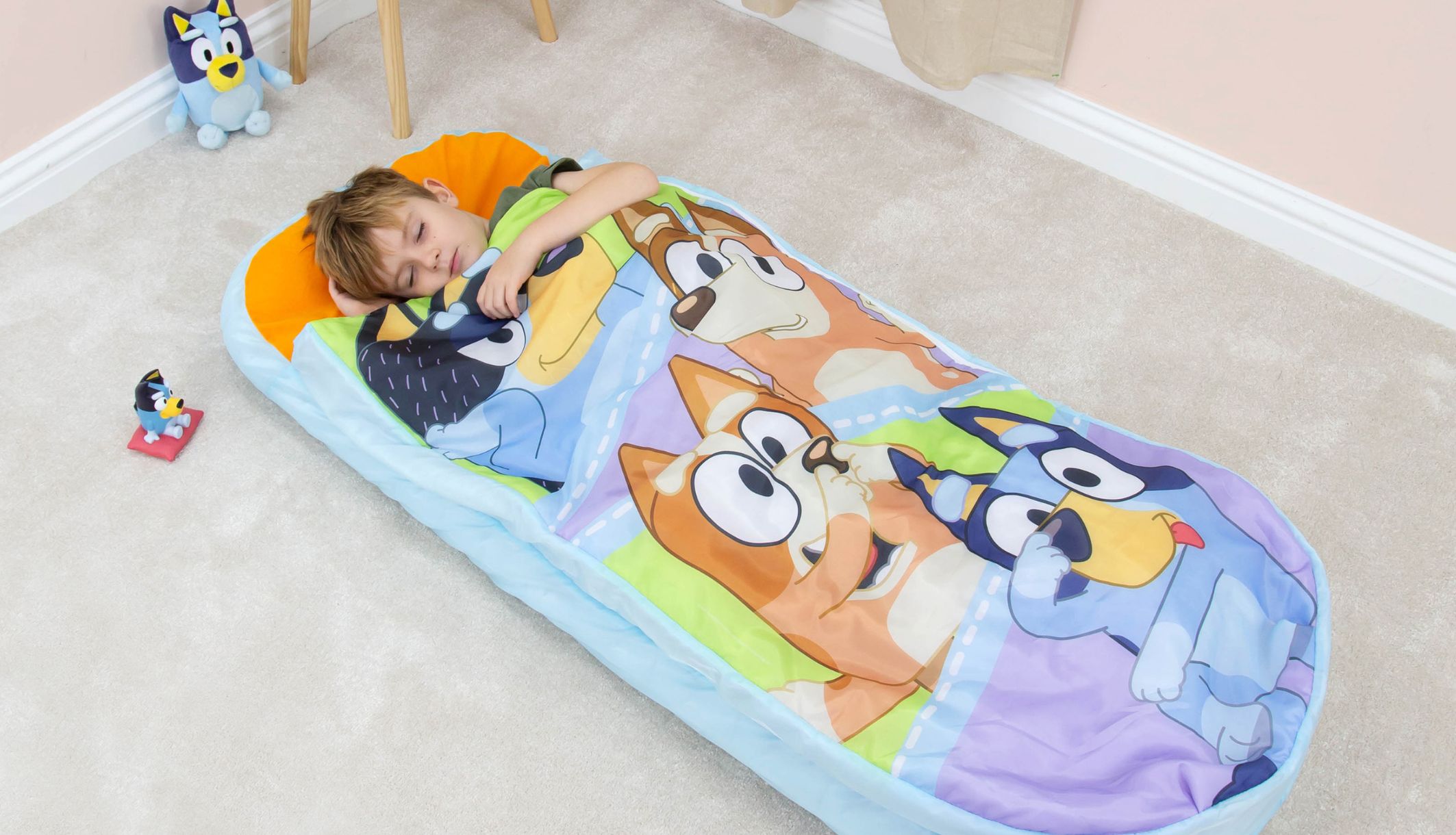 Jeune garçon dormant dans le lit d&#039;appoint gonflable ReadyBed Bluey dès 3 ans
