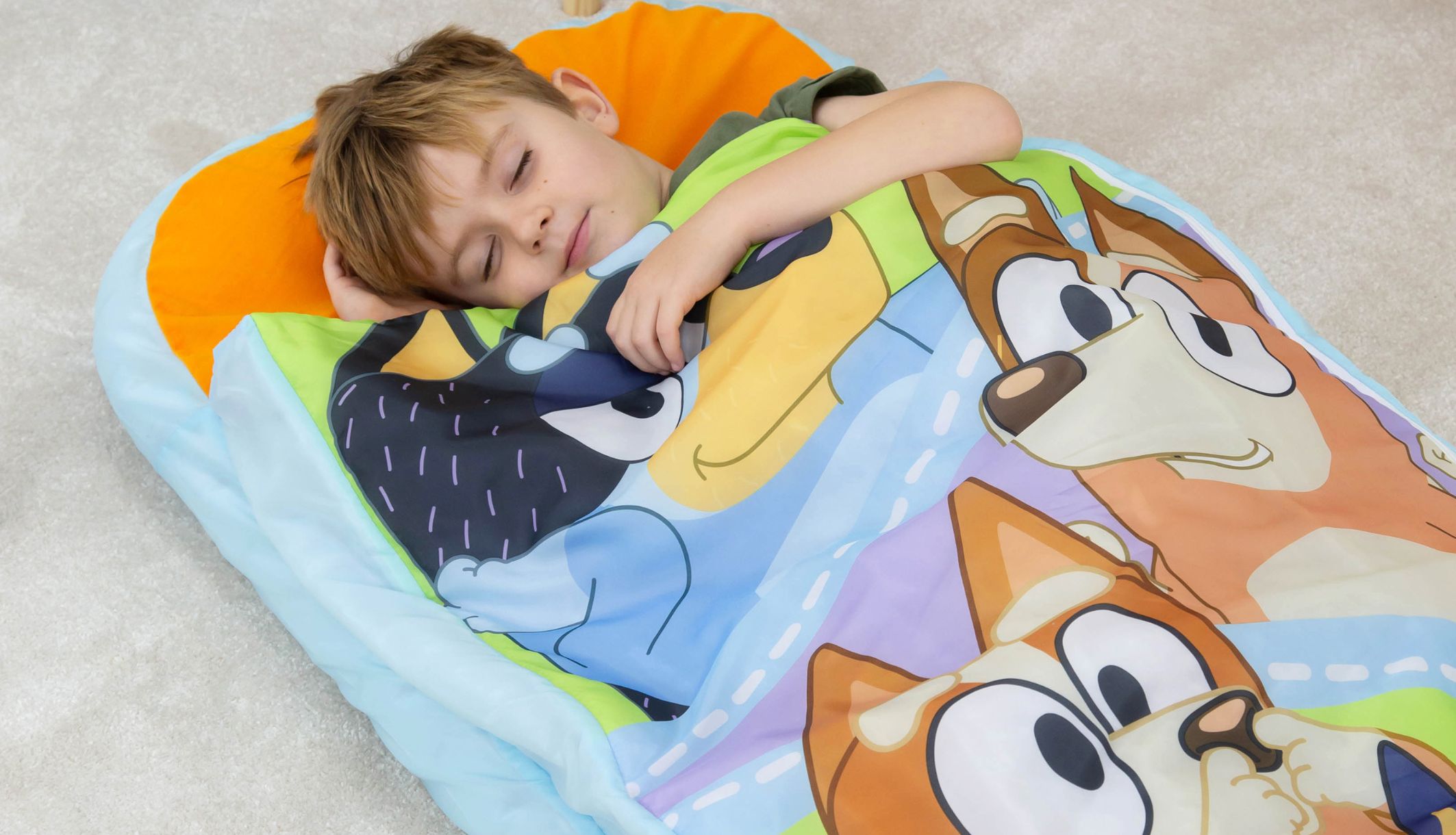 Zoom sur un jeune garçon dormant confortablement sur le lit d&#039;appoint ReadyBed Bluey