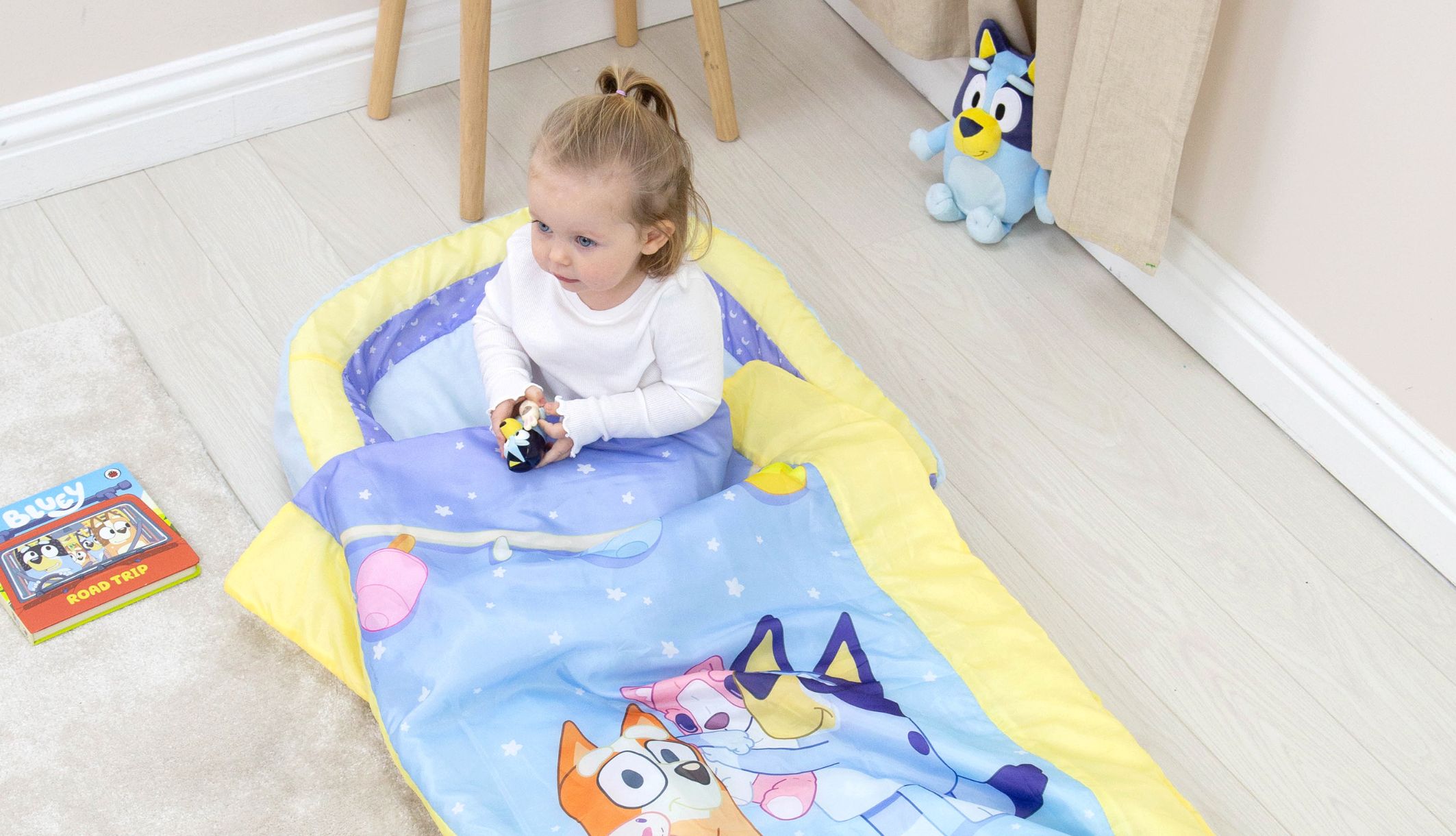 Jeune fille assis dans le lit d&#039;appoint ReadyBed gonflable Bluey