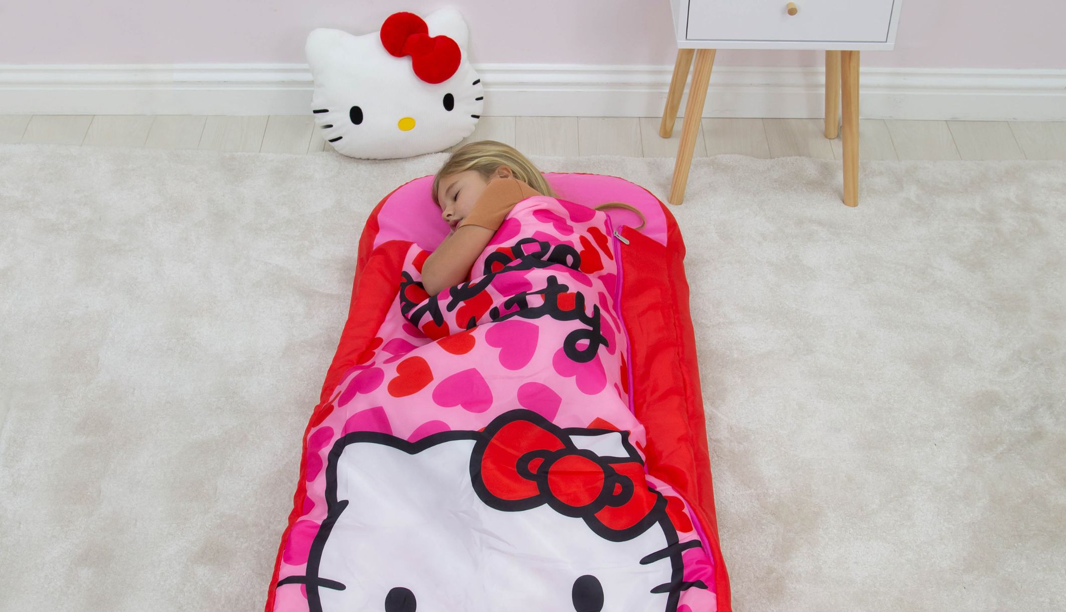 Jeune fille dormant dans le lit d&#039;appoint ReadyBed gonflable Hello Kitty