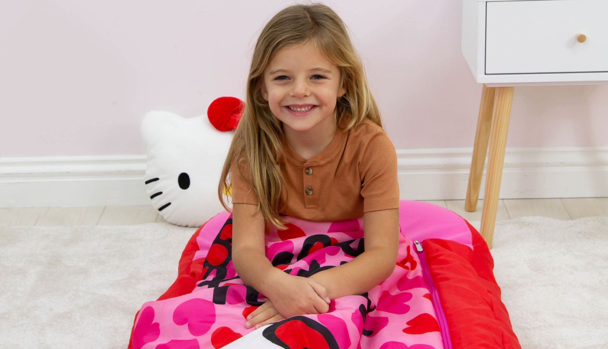 Jeune fille assis sur le ReadyBed gonflable 2-en-1 Hello Kitty