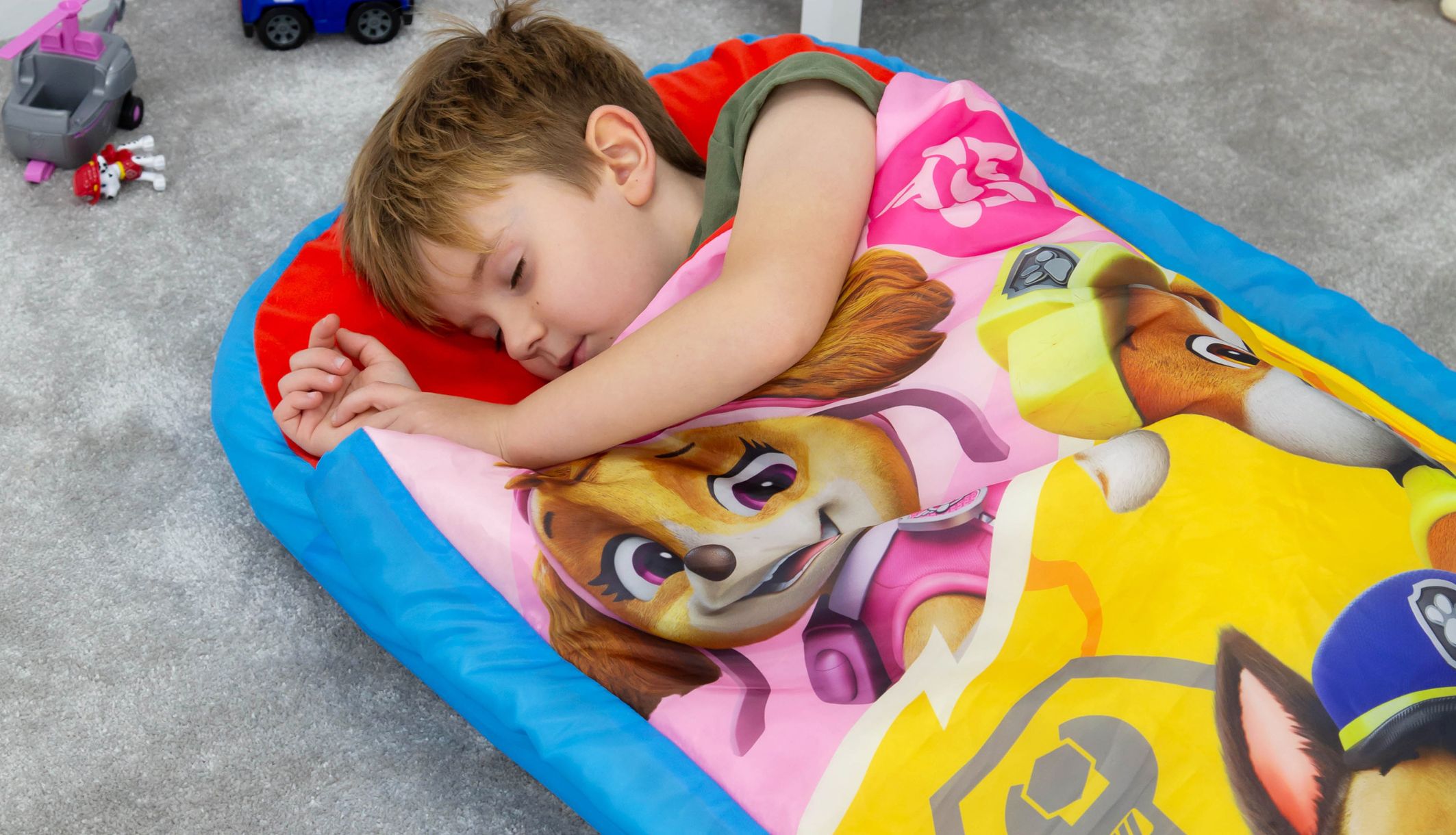 Zoom sur un jeune garçon dormant sur le lit d&#039;appoint gonflable Pat&#039;Pattrouille