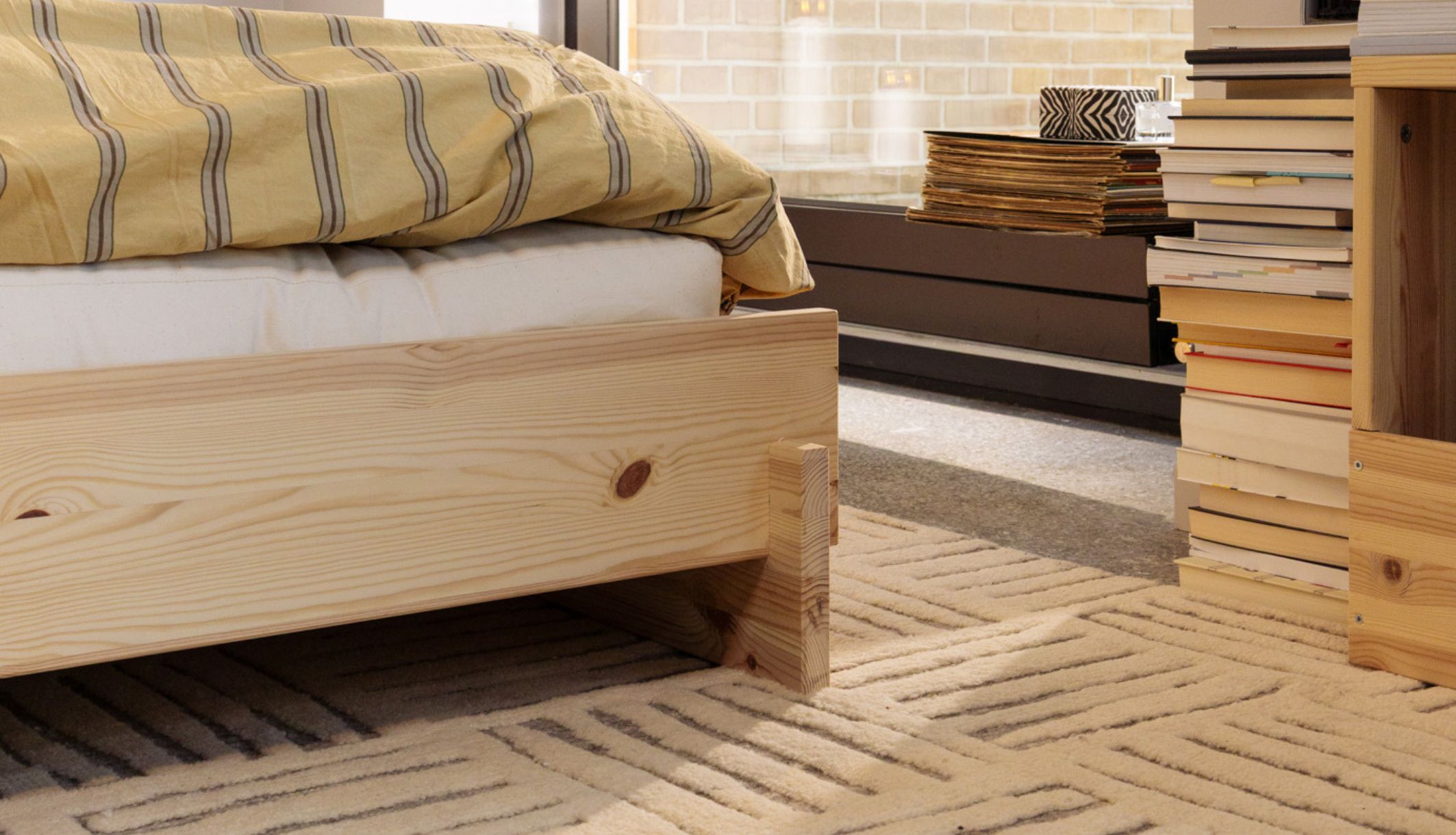 Structure basse du lit design scandinave avec une parure de lit jaune moutarde