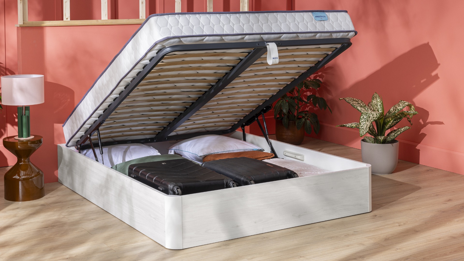 Lit coffre ouvert avec valises, oreillers à l&#039;intérieur