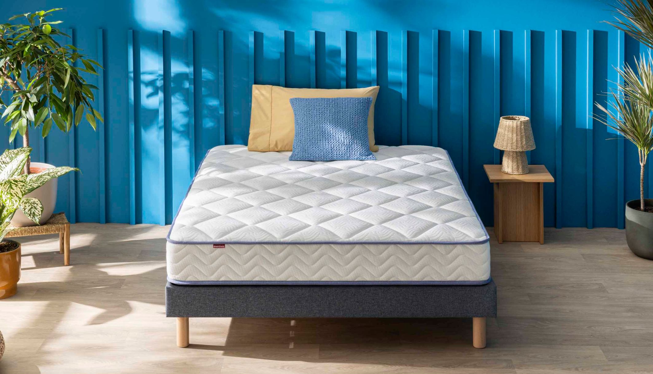 Vue de face du matelas Merinos Sweety à ressorts ensachés dans une chambre bleue.
