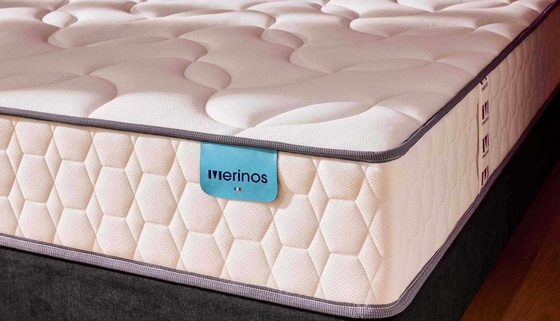 Détail du tissu alvéolé et du logo Merinos sur le matelas ressorts ensachés Cosy Lit.