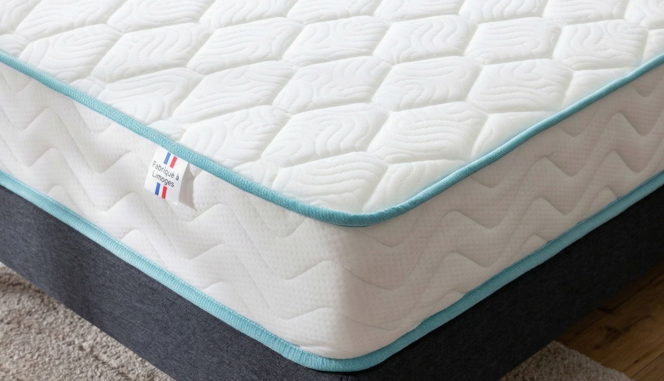 Détail du matelas Merinos fabriqué à Limoges montrant la qualité du garnissage et le liseré bleu.