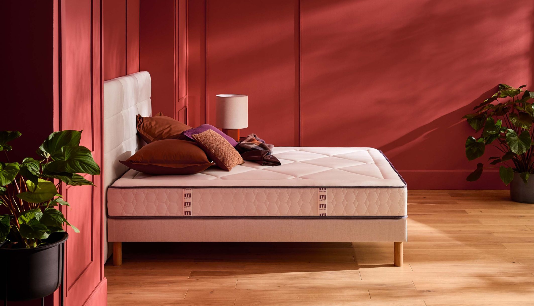 Matelas ressorts ensachés ferme Merinos Full Bed présenté dans une chambre aux tons terracotta.