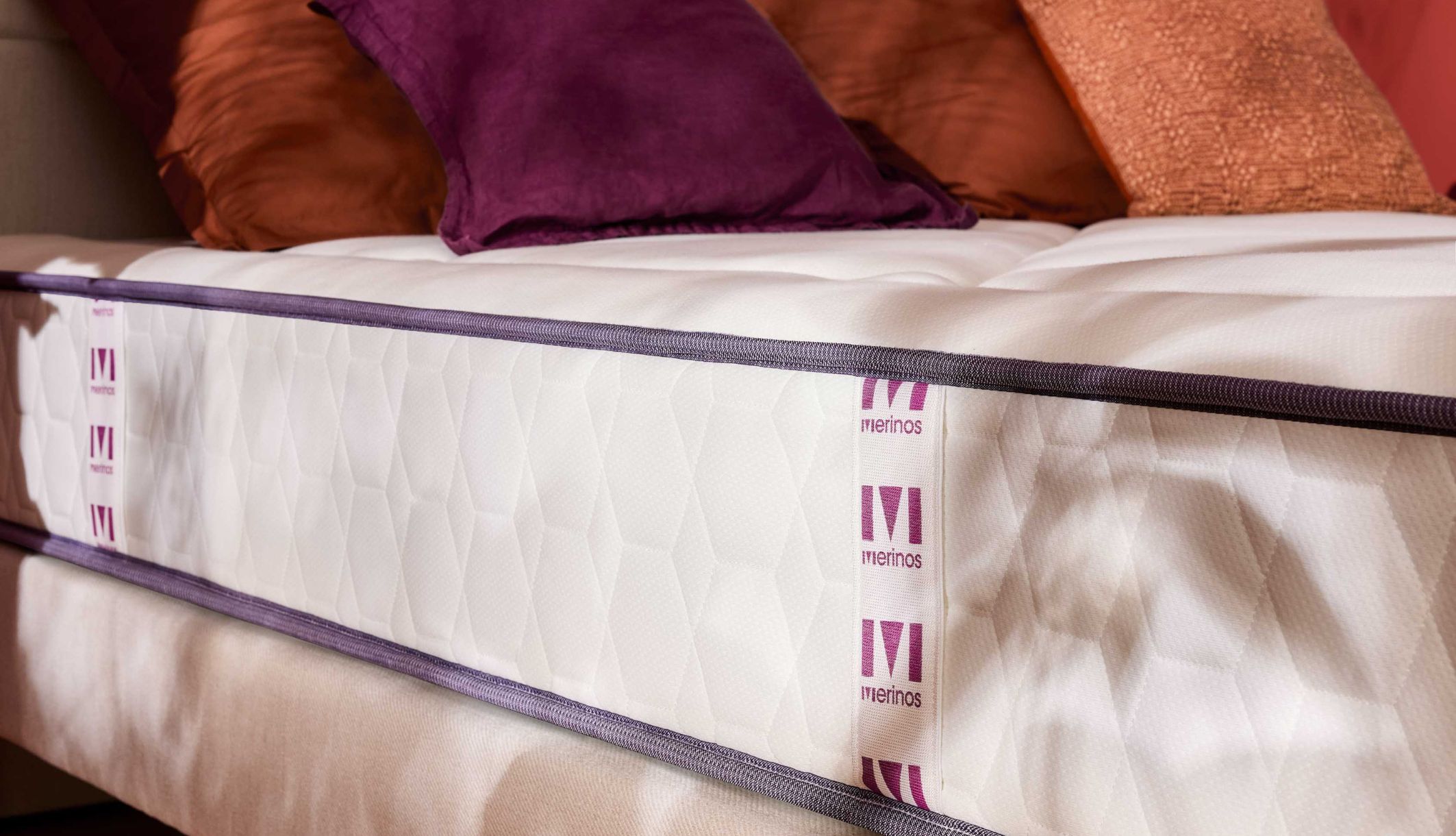 Détail des finitions latérales et du maintien du matelas ferme Merinos à ressorts ensachés.