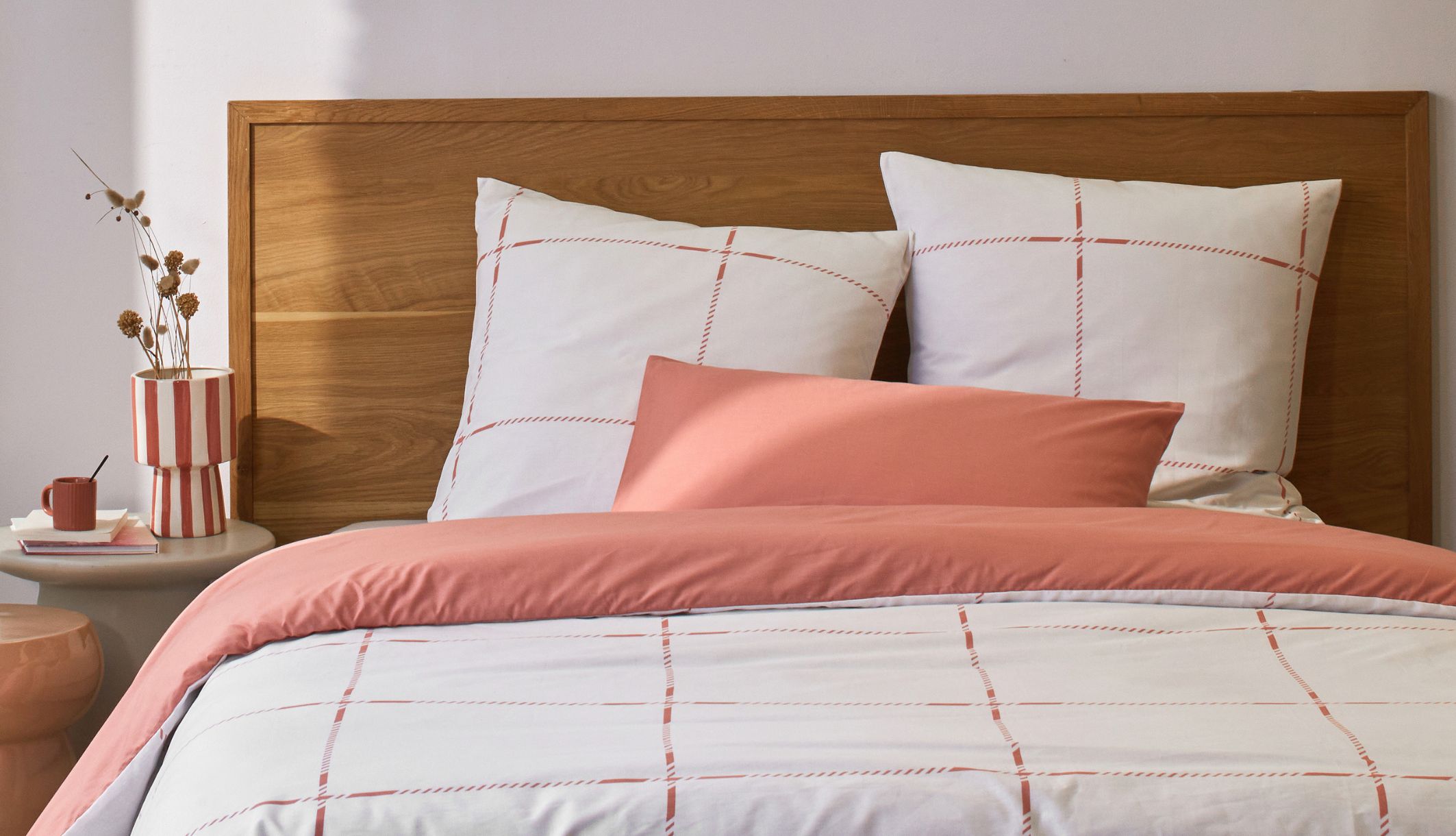 Lit douillet habillé d&#039;une parure de lit bicolore blanc et terracotta