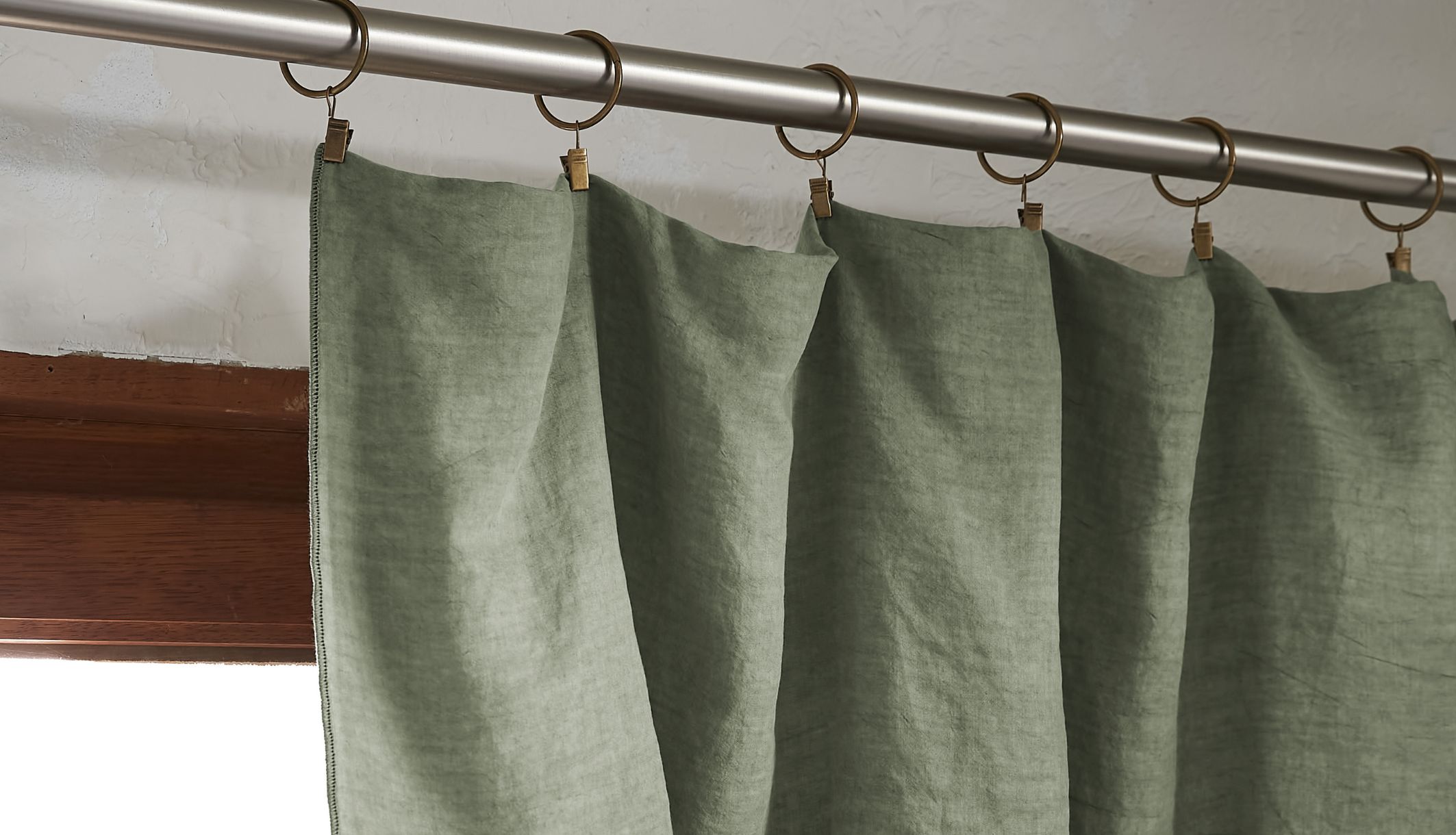 Rideau lyocell écologique coloris naturel suspendu dans une chambre à coucher lumineuse et épurée