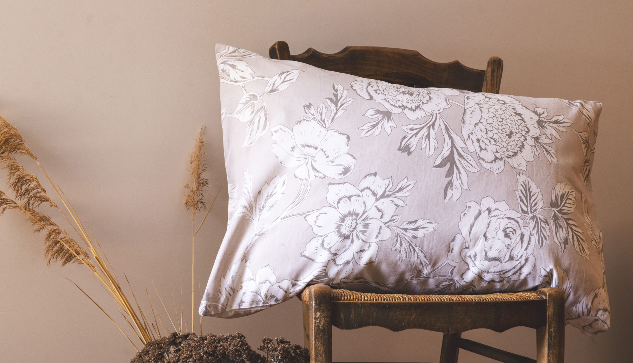 Taie d&#039;oreiller bucolique coton 57 fils posée sur une chaise en bois rustique décor champêtre