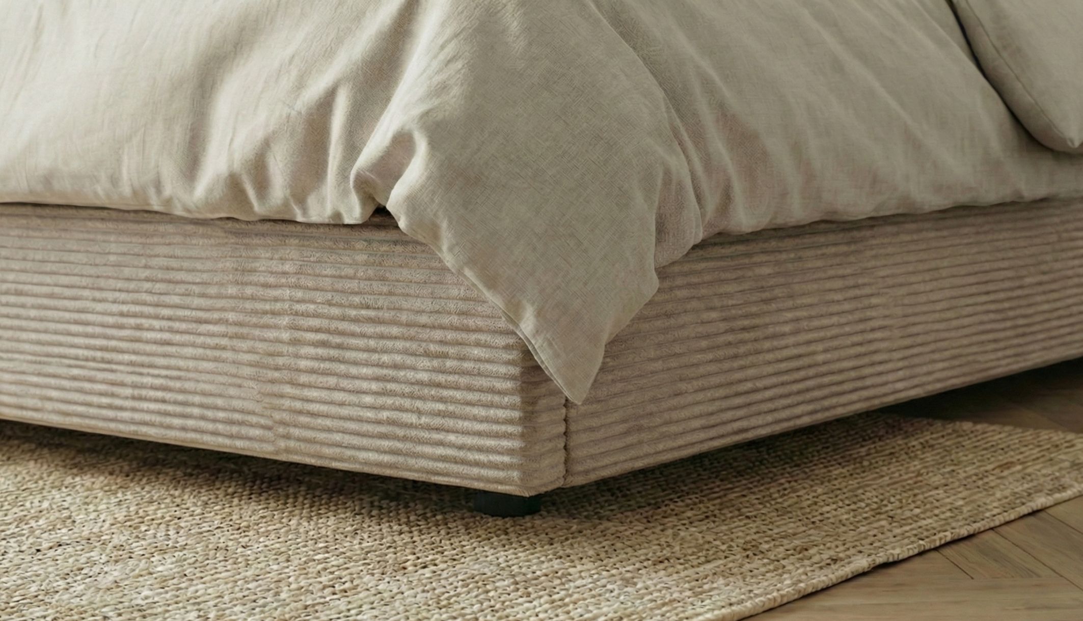 Zoom sur le bas du lit coffre en velours avec les pieds en PVC 