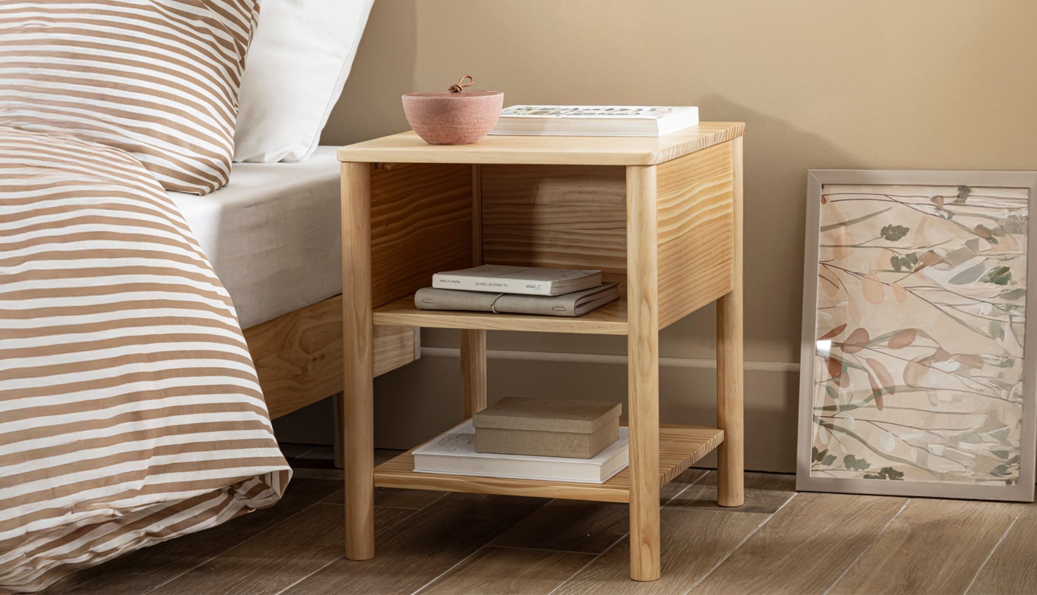 Table de chevet en pin massif avec niche de rangement décorée, idéale pour une chambre naturelle.