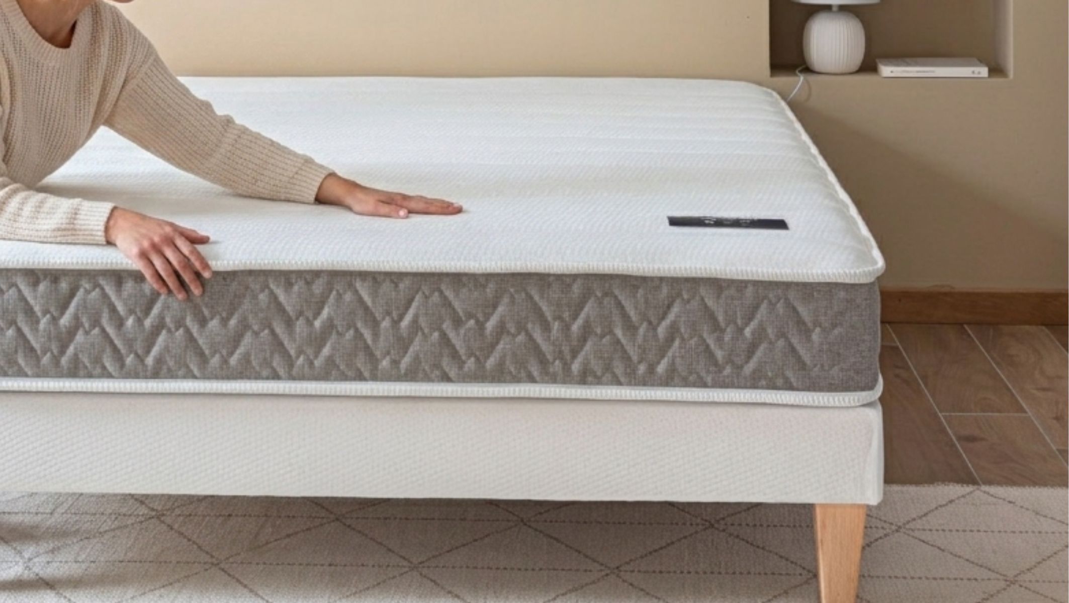 Main caressant le coutil doux du matelas Terre de Nuit Abondance 2.0 pour un confort optimal.