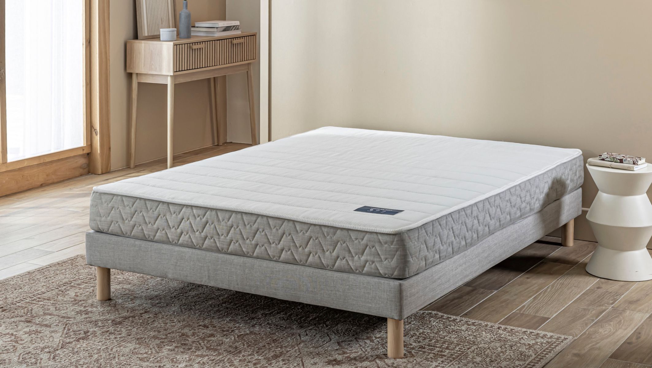 Sommier tapissier à lattes recouvertes Éveil Terre de Nuit gris avec matelas en chambre.