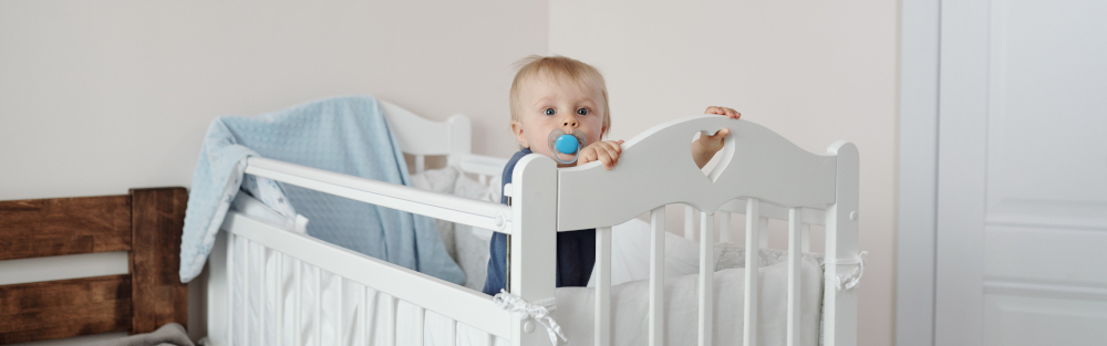 bebe dans son lit à barreaux