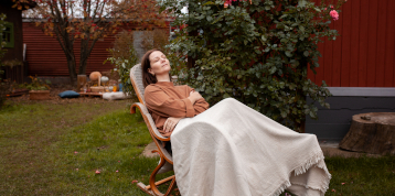 femme dormant assise dans jardin sur chaise à bascule