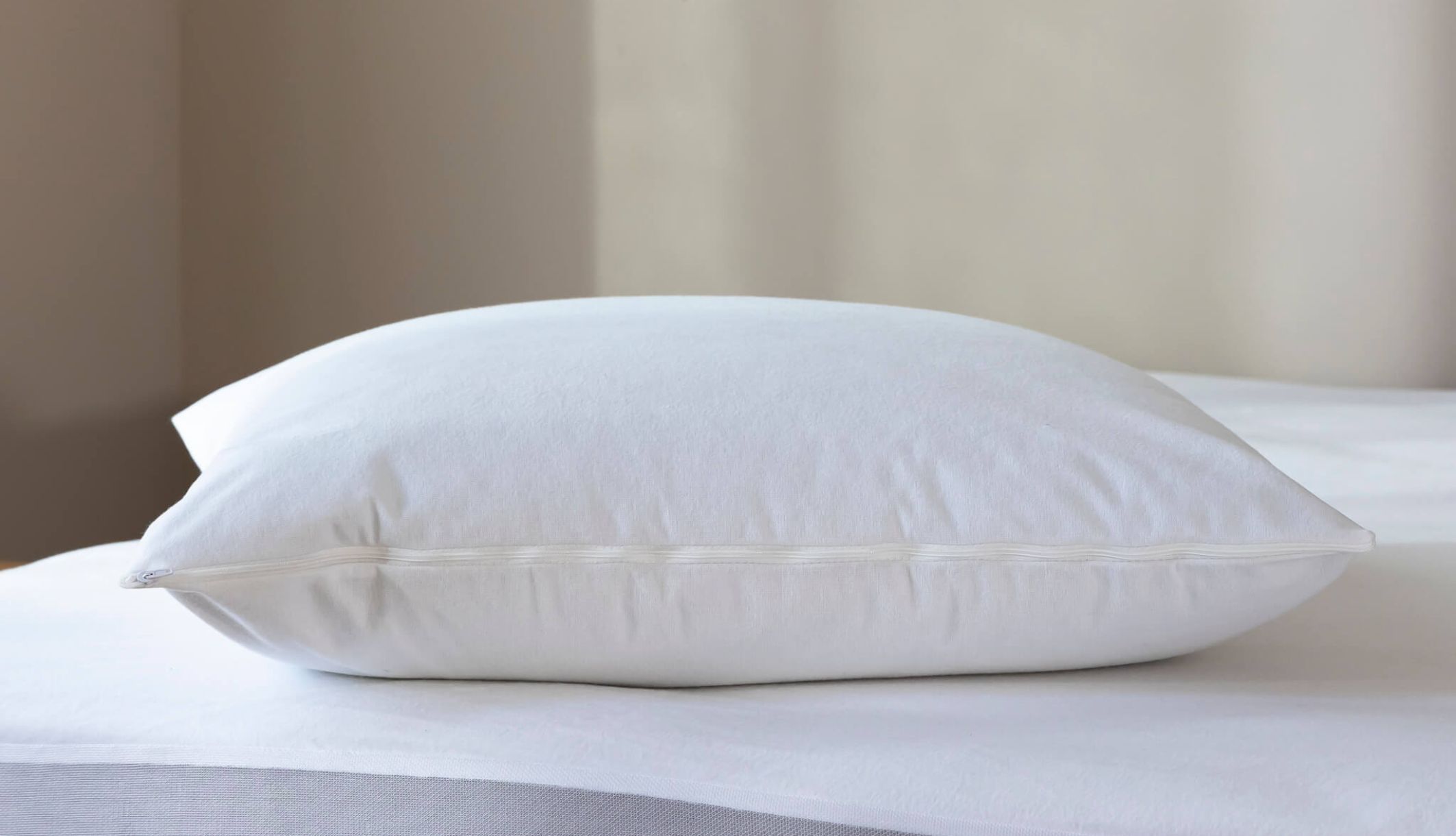 Protection oreiller en molleton coton bio installé sur un lit