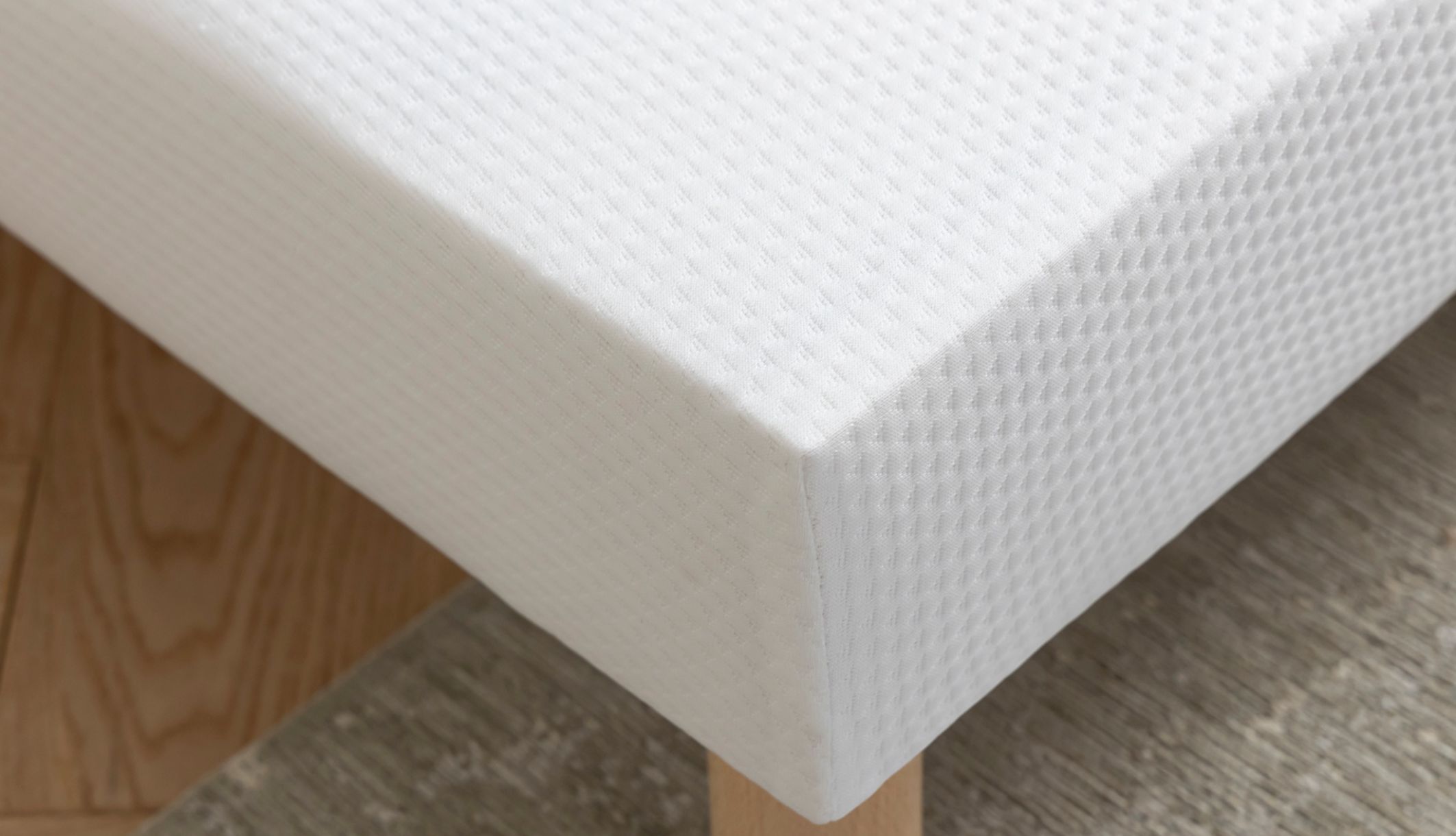 Gros plan sur le tissu blanc protecteur des lattes recouvertes du lit.